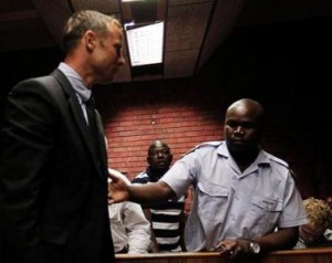 South African 'Blade Runner' Oscar Pistorius is escorted by police during his court appearance in Pretoria