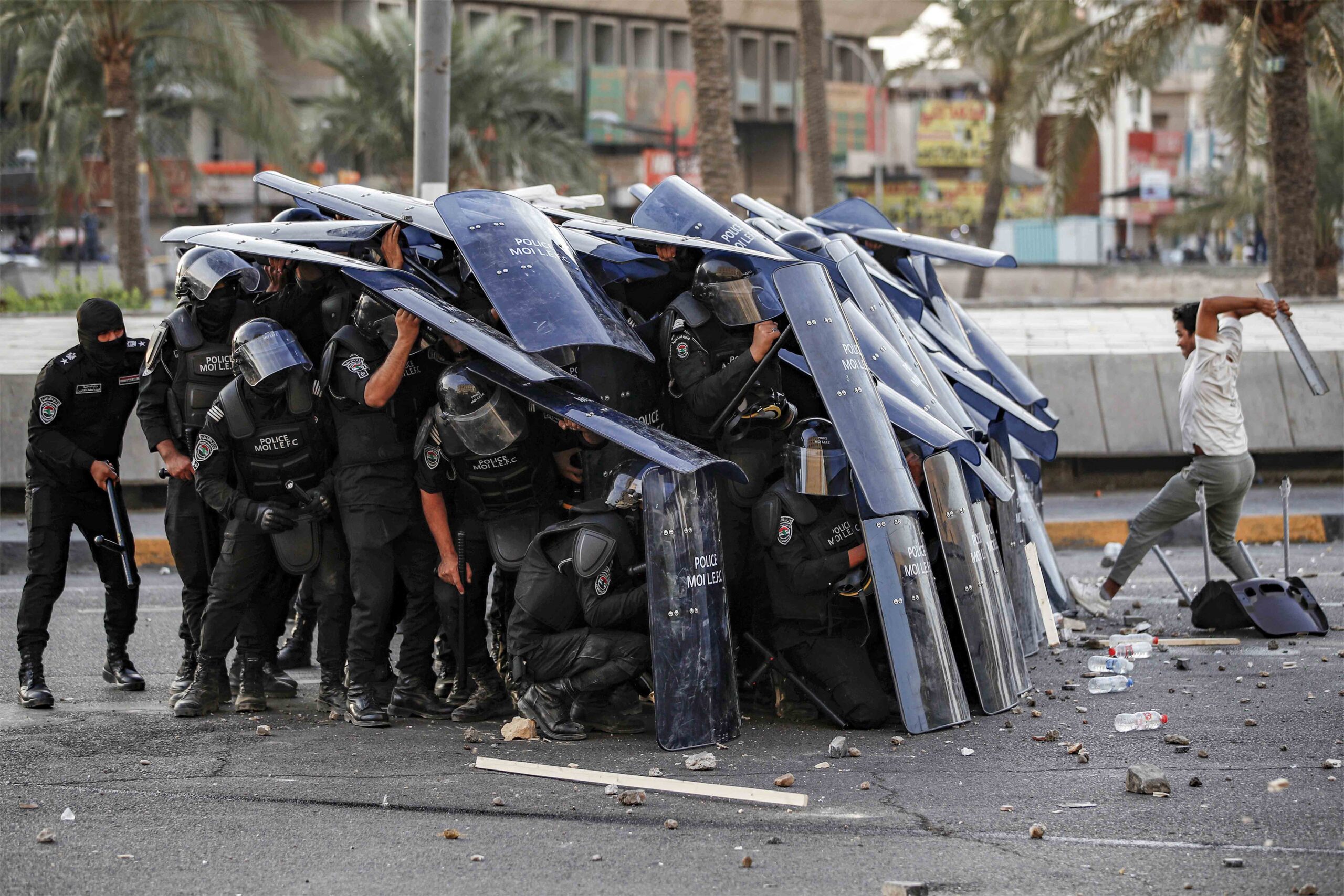 Iraqi Riot Control Police Take Cover Behind Their Shields During