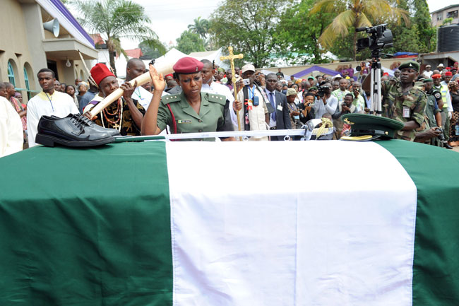 In this file photograph taken on March 2, 2012, a soldier salutes after arranging the boots and cap on the casket of Nigeria's secessionist leader Odumegwu Ojukwu during his funeral at his native Nnewi country home in Anambra State eastern Nigeria. Pius Utomi EKPEI / AFP