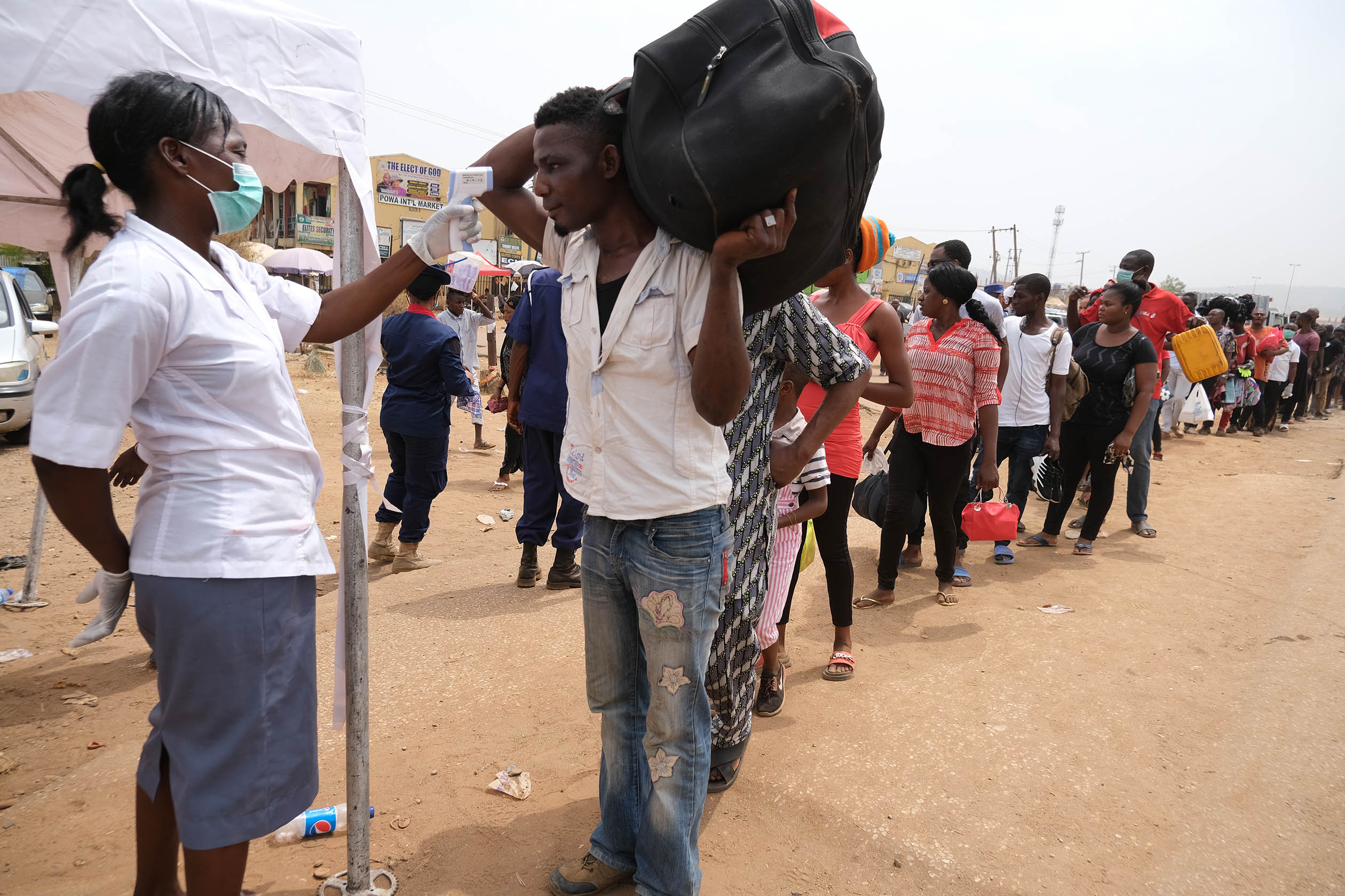 People queue to have their temperatures checked at a border-end of Abuja, as the authorities try to limit the spread of the coronavirus disease (COVID-19) in Abuja, Nigeria March 30, 2020. Photo: Sodiq Adelakun / Channels TV