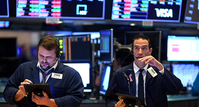 In this file photo Traders work during the opening bell at the New York Stock Exchange (NYSE) on March 19, 2020, at Wall Street in New York City. Johannes EISELE / AFP