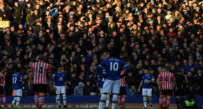 In this file photo taken on January 02, 2017 Fans shield their eyes from the Sun during the English Premier League football match between Everton and Southampton at Goodison Park in Liverpool, north west England. Paul ELLIS / AFP