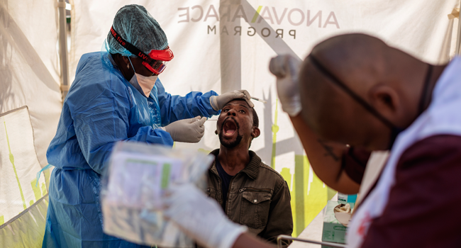 Doctors Without Borders (MSF) nurse Bhelekazi Mdlalose (L), 51, performs a swab test for COVID-19 coronavirus on a health worker at the Vlakfontein Clinic in Lenasia, Johannesburg, on May 13, 2020. Michele Spatari / AFP