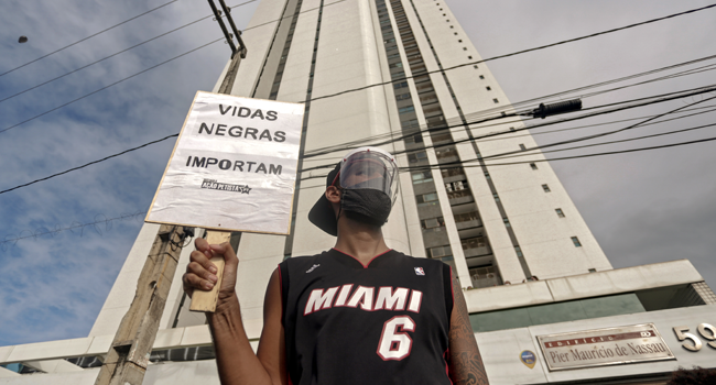 A demonstrator holds a sign reading "Black Lives Matter" in demand of justice for the death of five-year-old Miguel Otavio Santana da Silva, the son of a black maid who on June 2 fell from the ninth floor of a building while under the watch of his mother's white employer, in Recife, Pernambuco State, in northeastern Brazil, on June 5, 2020. Leo Malafaia / AFP