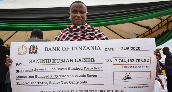 Tanzanian small-scale miner Saniniu Kuryan Laizer, 52, poses with the enlarged cheque copy from the government after selling two of the biggest of the country's precious gemstones, Tanzanite, during the ceremony for his historical discovery in Manyara, northern Tanzania, on June 24, 2020. Filbert RWEYEMAMU / AFP