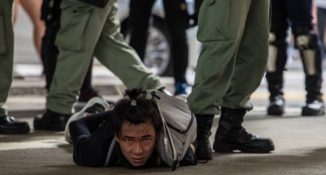 Riot police detain a man as they clear protesters taking part in a rally against a new national security law in Hong Kong on July 1, 2020, on the 23rd anniversary of the city's handover from Britain to China. Hong Kong police made the first arrests under Beijing's new national security law on July 1 as the city greeted the anniversary of its handover to China with protesters fleeing water cannon. DALE DE LA REY / AFP