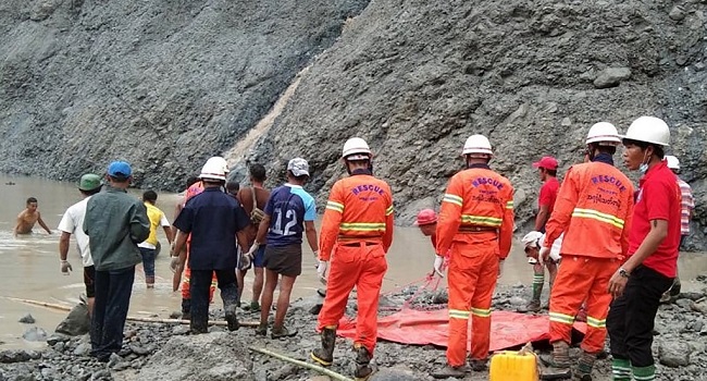 This handout from the Myanmar Fire Services Department taken and released on July 2, 2020 shows rescuers attempting to locate survivors after a landslide at a jade mine in Hpakant, Kachin state. - The bodies of at least 50 jade miners were pulled from the mud on July 2 after a landslide in northern Myanmar, fire services said, as monsoon rains worsen already deadly conditions. (Photo by Handout / MYANMAR FIRE SERVICES DEPARTMENT / AFP) / 