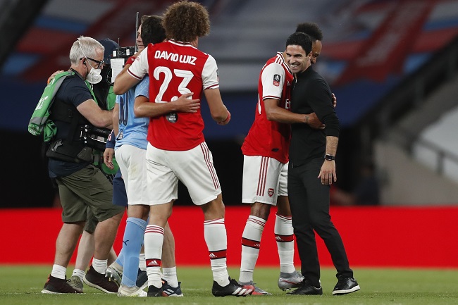 Arsenal's Spanish head coach Mikel Arteta (R) embraces Arsenal's Gabonese striker Pierre-Emerick Aubameyang (2R) at the end of the English FA Cup semi-final football match between Arsenal and Manchester City at Wembley Stadium in London, on July 18, 2020. (Photo by MATTHEW CHILDS / POOL / AFP) / NOT FOR MARKETING OR ADVERTISING USE / RESTRICTED TO EDITORIAL USE