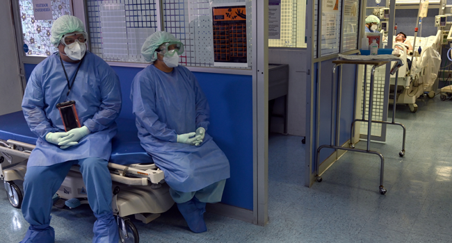 Health professionals treating COVID-19 patients sit on a stretcher as they take a break at the Juarez de Mexico Hospital, in Mexico City, on July 8, 2020. COVID-19 patients stay at convalescence rooms as a prelude to happy recovery and a future discharge. RODRIGO ARANGUA / AFP