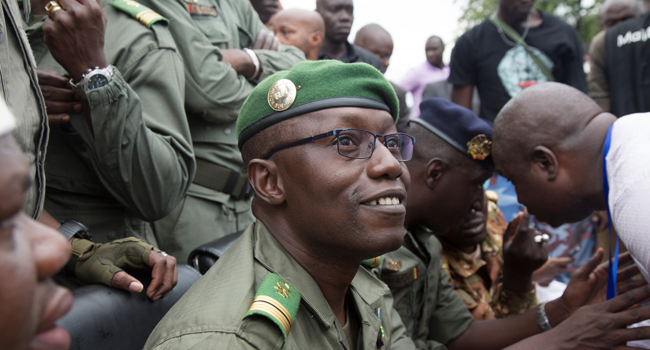 Colonel Malick Diaw (C), vice-president of the CNSP (National Committee for the Salvation of the People) smiles at a crowd of supporters as he arrives escorted by Malian soldiers at the Independence square in Bamako, on August 21, 2020. ANNIE RISEMBERG / AFP