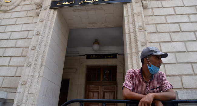 A man waits outside the Sidi Mohamed tribunal in the Algerian capital Algiers where the trial of detained journalist Khaled Drareni began, on August 3, 2020. RYAD KRAMDI / AFP