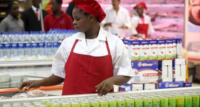 A shop assistant arranges products at the South African firm Shoprite's main store in Nigeria's commercial capital Lagos April 29, 2010. REUTERS/Akintunde Akinleye