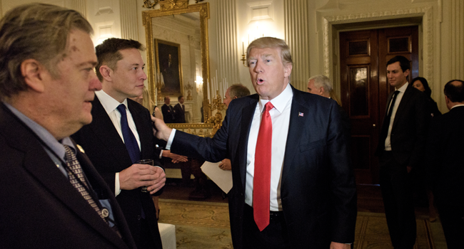 In this file photo former Trump advisor Steve Bannon (L) watches as US President Donald Trump greets Elon Musk, SpaceX and Tesla CEO, before a policy and strategy forum with executives in the State Dining Room of the White House February 3, 2017 in Washington, DC. Brendan Smialowski / AFP