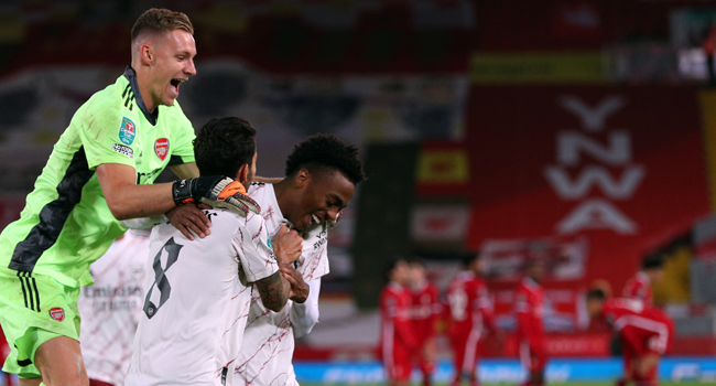 Arsenal's German goalkeeper Bernd Leno (L) celebrates with Arsenal's English midfielder Joe Willock (3L) after winning a penalty shoot out during the English League Cup fourth round football match between Liverpool and Arsenal at Anfield in Liverpool, north west England on October 1, 2020. Peter Byrne / AFP