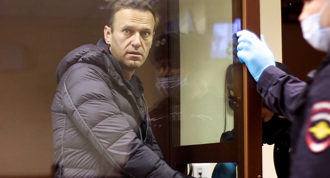 This screen grab from a handout footage provided by the Babushkinsky district court on February 5, 2021, shows Russian opposition leader Alexei Navalny, charged with defaming a World War II veteran, looking from inside a glass cell during a court hearing in Moscow. Handout / Moscow's Babushkinsky district court press service / AFP