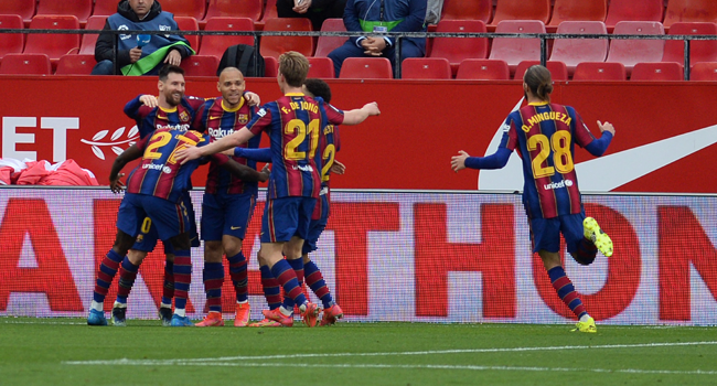 Barcelona's Argentinian forward Lionel Messi (L) celebtates with teammates after scoring during the Spanish league football match between Sevilla FC and FC Barcelona at the Ramon Sanchez Pizjuan stadium in Seville on February 27, 2021. CRISTINA QUICLER / AFP