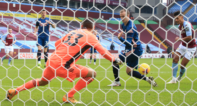 Aston Villa's English striker Ollie Watkins (R) scores the opening goal past Arsenal's Australian goalkeeper Mat Ryan (L) during the English Premier League football match between Aston Villa and Arsenal at Villa Park in Birmingham, central England on February 6, 2021. Nick Potts / POOL / AFP