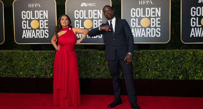 This handout photo courtesy of the HFPA shows Salma Hayek and Sterling K. Brown elbow bump as they arriving for the 78th Annual Golden Globe Awards in Beverly Hills, California on February 28, 2021.  HFPA / AFP