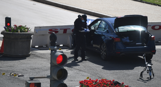 A police officer inspects the scene of a car that crashed into a barrier near the US Capitol on April 2, 2021 in Washington, DC. Eric BARADAT / AFP