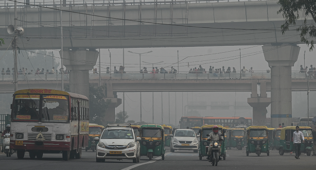 Commuters make their way along a street amid smoggy conditions in New Delhi on November 5, 2021. Prakash SINGH / AFP