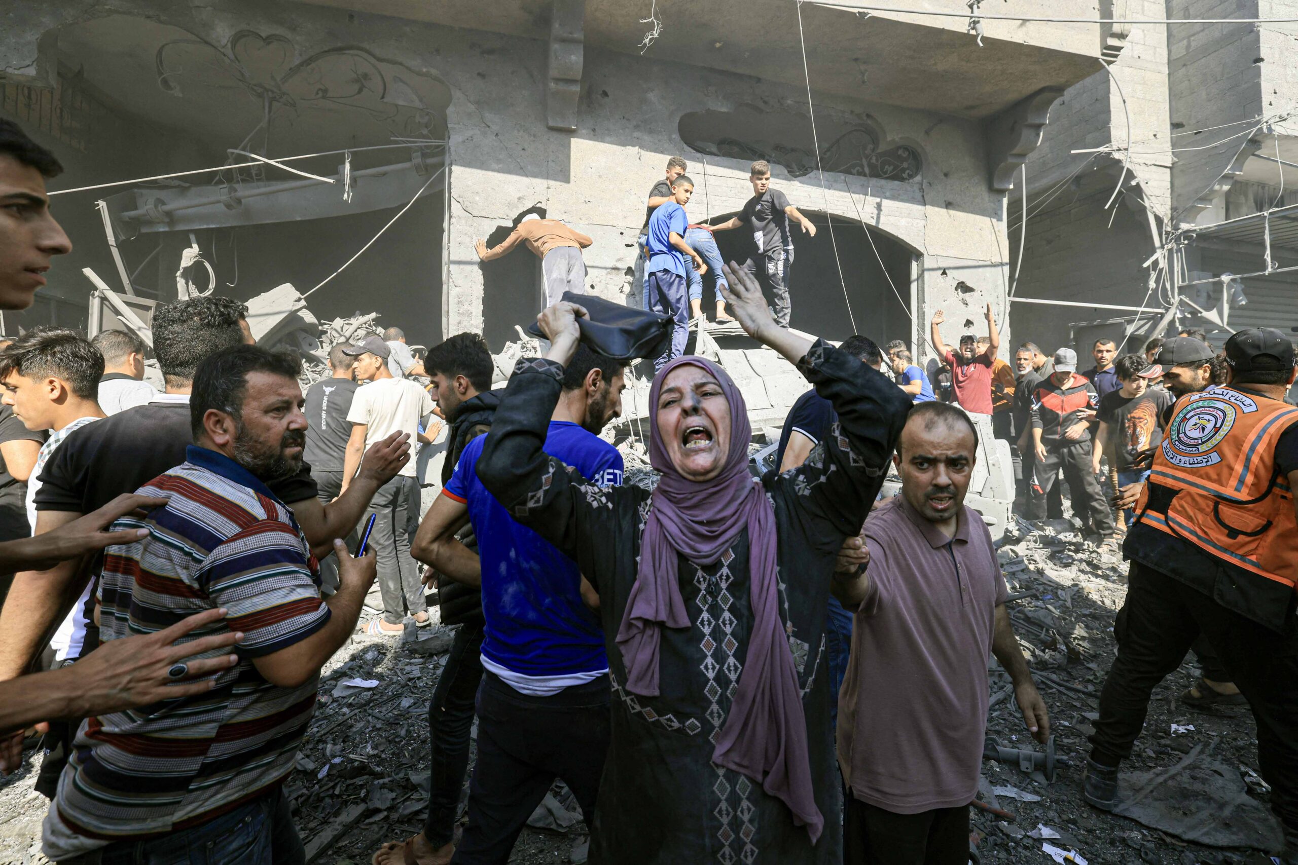 A Palestinian woman reacts as others rush to look for victims in the ...