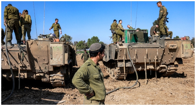 Israeli soldiers refuel a tracked vehicle at a position near the border with the northern Gaza Strip in southern Israel on December 19, 2023, amid the ongoing conflict between Israel and the Palestinian militant group Hamas.