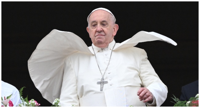 (FILES) The wind lifts Pope Francis mantilla as he stands at the central loggia of St. Peter's basilica during the Easter 'Urbi et Orbi' message and blessing to the City and the World as part of the Holy Week celebrations, in the Vatican on March 31, 2024. (Photo by Tiziana FABI / AFP)
