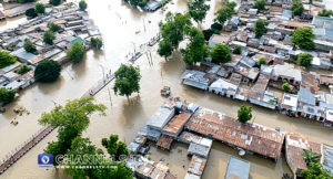 A flooded area in Maiduguri, with many houses and streets submerged under water. The flood covers several streets, with the water extending deep into the residential area.